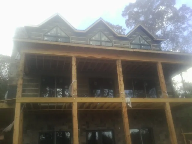Dormers and porch framing on a large log home under construction — Roof Coating work by our crew in Mountain Home