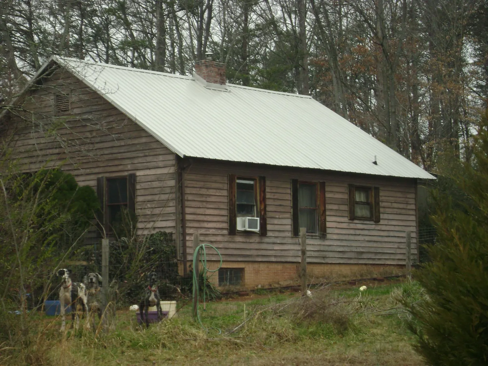 White metal roof on an old wood sided farmhouse, from a Metal Roof Installation job in Mountain Home